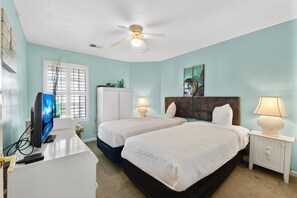 A hotel room with two beds, a desk with a computer, a TV, and a ceiling fan. - Fairways 26E (Myrtle Beach)