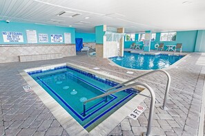 Ein Innenpool mit Sicherheitszeichen, einer Wasserspende und Liegestühlen.