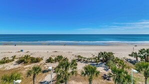 A beach with clear skies, palm trees, and a sandy shore. - Ocean Blue 303 (Myrtle Beach)