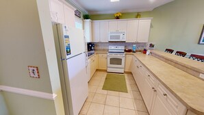 A compact kitchen with white cabinets, a microwave, an oven, and a refrigerator. - Magnolia Pointe Luster Leaf 4895-402 (Myrtle Beach)