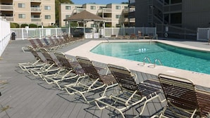 Area piscina con sedie a sdraio e un gazebo.
