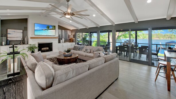 A spacious living room with a large sectional sofa, a fireplace, and a view of the lake. - Southern Sunrise (Mooresville)