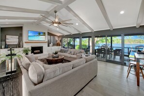 A spacious living room with a large sectional sofa, a fireplace, and a view of the lake. - Southern Sunrise (Mooresville)