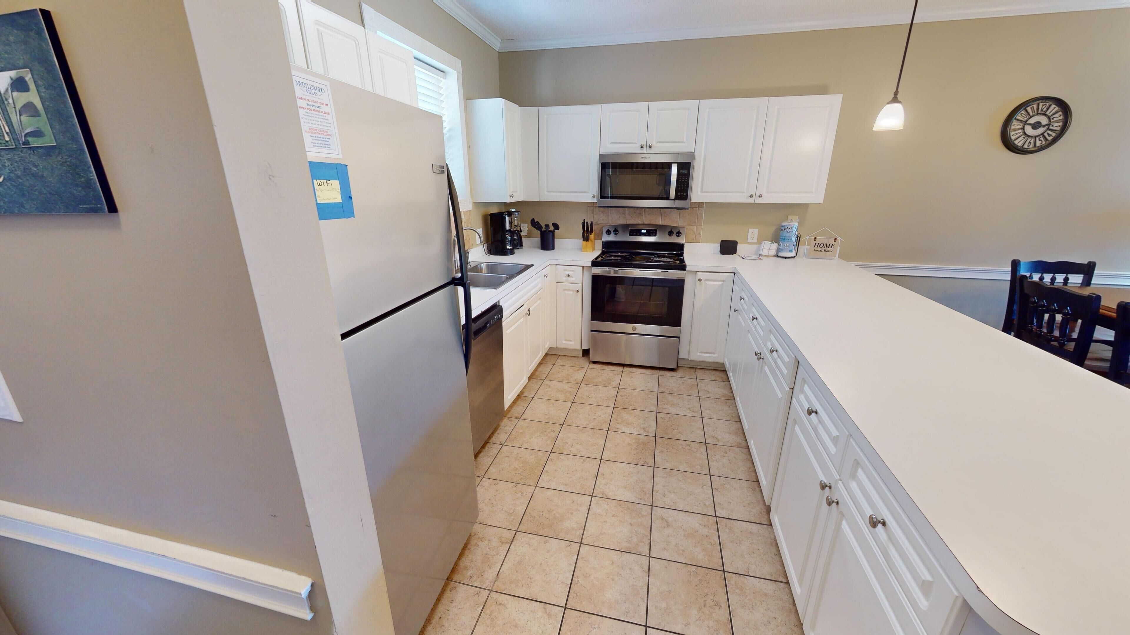 A modern kitchen with white cabinets, a stainless steel oven, a microwave, and a dishwasher.
