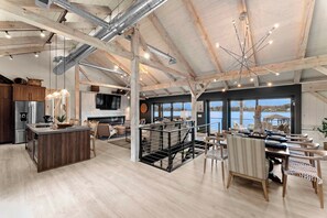 Ein großzügiger Loft-Innenraum mit großer Küche, Essbereich und Blick auf das Wasser.
