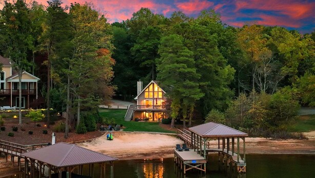 Un chalet au bord du lac, doté d’une terrasse, d’un quai et d’un abri pour bateaux.