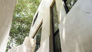 Un edificio moderno con grandes ventanales y fachada de hormigón.