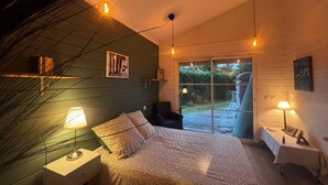 A bedroom with a bed, two bedside tables, a chair, and a window with a view of the outdoors. - House between pond and ocean - ideal for a family (Lège-Cap-Ferret)
