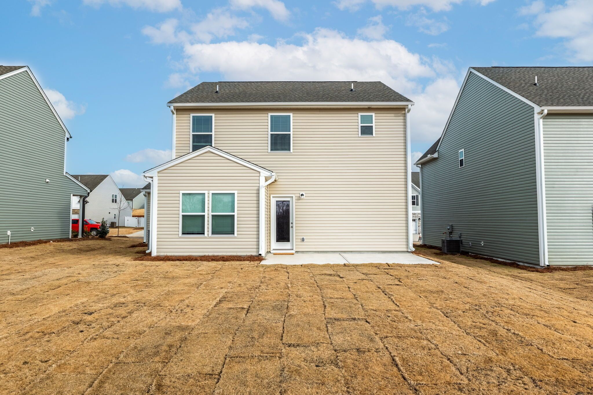 A two-story house with a front porch, a garage, and a driveway.