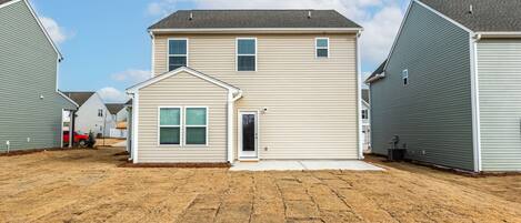 A two-story house with a front porch, a garage, and a driveway.