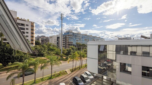 A modern building with a parking lot and a street view. - Apt w/ 1 Suite in BSB - Nrm0205 (Brasília)