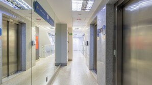 A modern hotel corridor with glass doors, a sign indicating room 213, and an elevator. - Apt w/ 1 Suite in BSB - Nrm0205 (Brasília)