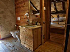 Une salle de bain en bois avec un lavabo, des toilettes et un miroir.