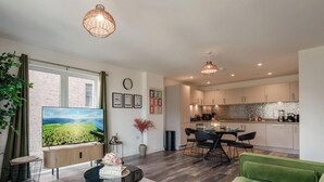 A modern living room with a TV, a dining area, and a kitchen. - City Central | Free Parking | O2 | University (Birmingham)