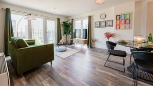 A modern living room with a sofa, dining table, chairs, and a large window. - City Central | Free Parking | O2 | University (Birmingham)
