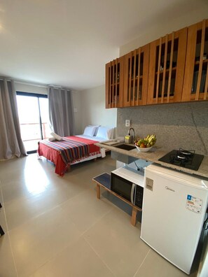 A compact hotel room with a bed, kitchenette, and a small dining area. - Villa Visgo Itacaré (Itacaré)