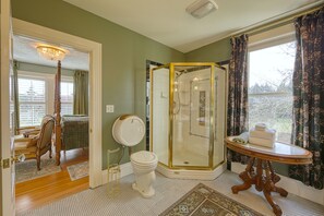 A bathroom with a glass-enclosed shower, a toilet, and a vanity with a mirror. - The Allen House (Ridgefield)