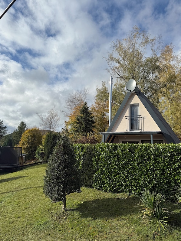 A house with a satellite dish, a window, and a triangular roof.