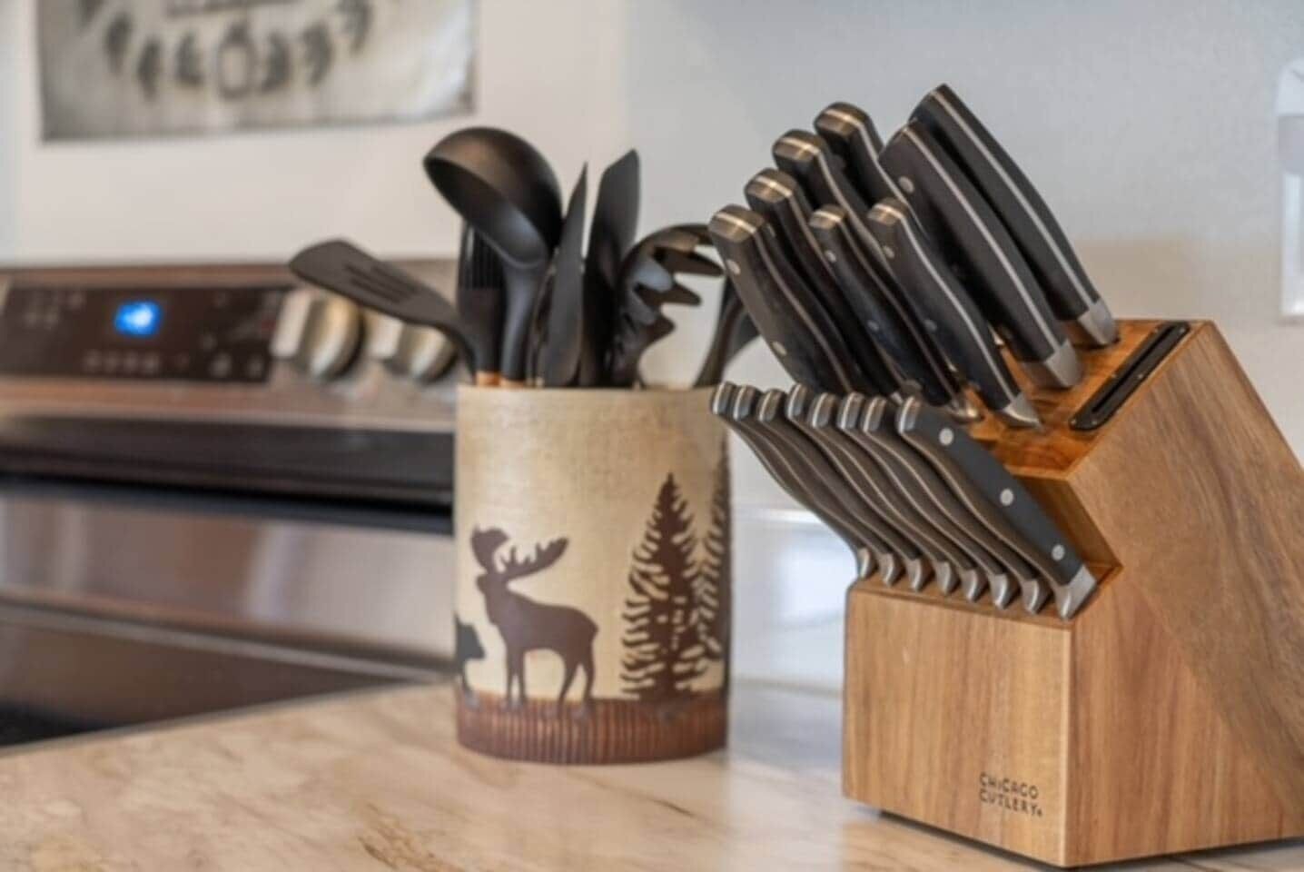 A kitchen counter with a knife block and a utensil holder.
