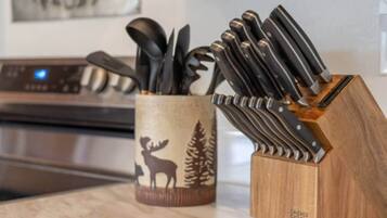 A kitchen counter with a knife block and a utensil holder.