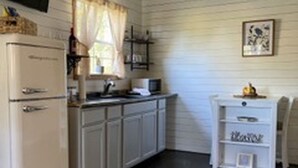 A compact kitchen with white cabinetry, a built-in microwave, and a small countertop. - Charming 1BR Pet-Friendly Cottage - Peaceful Stay Near Downtown New Albany (New Albany)