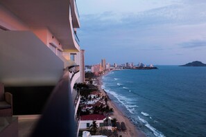 Ein Küstenhotel mit Balkon mit Blick auf den Strand und den Ozean.