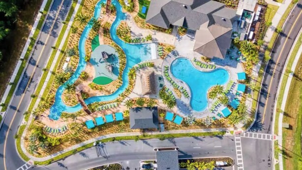 An aerial view of a resort with multiple swimming pools, landscaped areas, and a road surrounding the property. - Families Deluxe Dream Vacation, 10 min from Disney (Kissimmee)