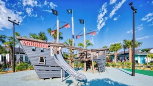 A playground with a pirate-themed slide and climbing structures. - Families Deluxe Dream Vacation, 10 min from Disney (Kissimmee)