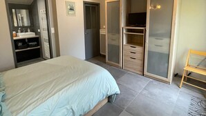 A bedroom with a bed, a wardrobe, and a bathroom. - Vent de Mer - House with a pool for 8 people (Bretignolles-sur-Mer)