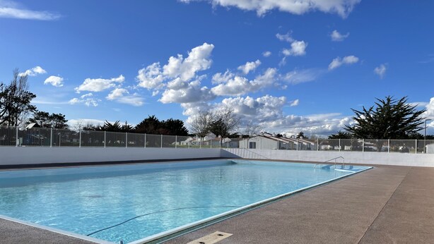 A rectangular swimming pool with a clear blue water surface, surrounded by a concrete deck and a white fence. - Vent de Mer - House with a pool for 8 people (Bretignolles-sur-Mer)