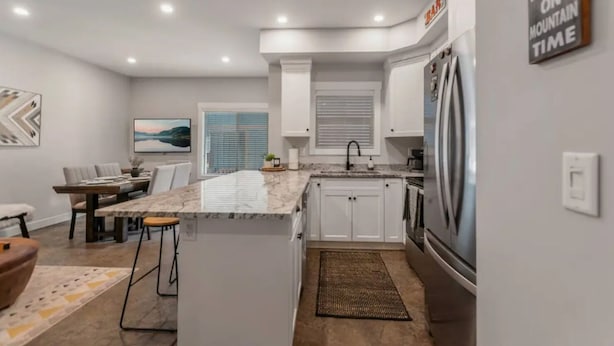 A modern kitchen with white cabinets, a granite countertop, and stainless steel appliances. - Apex Slopeside Escape ~ Ski in/out with Hot tub (Keremeos)