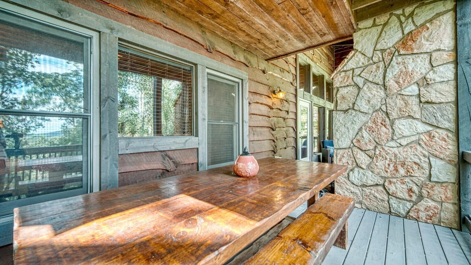 Una mesa de madera con bancos en un ambiente rústico de cabaña.