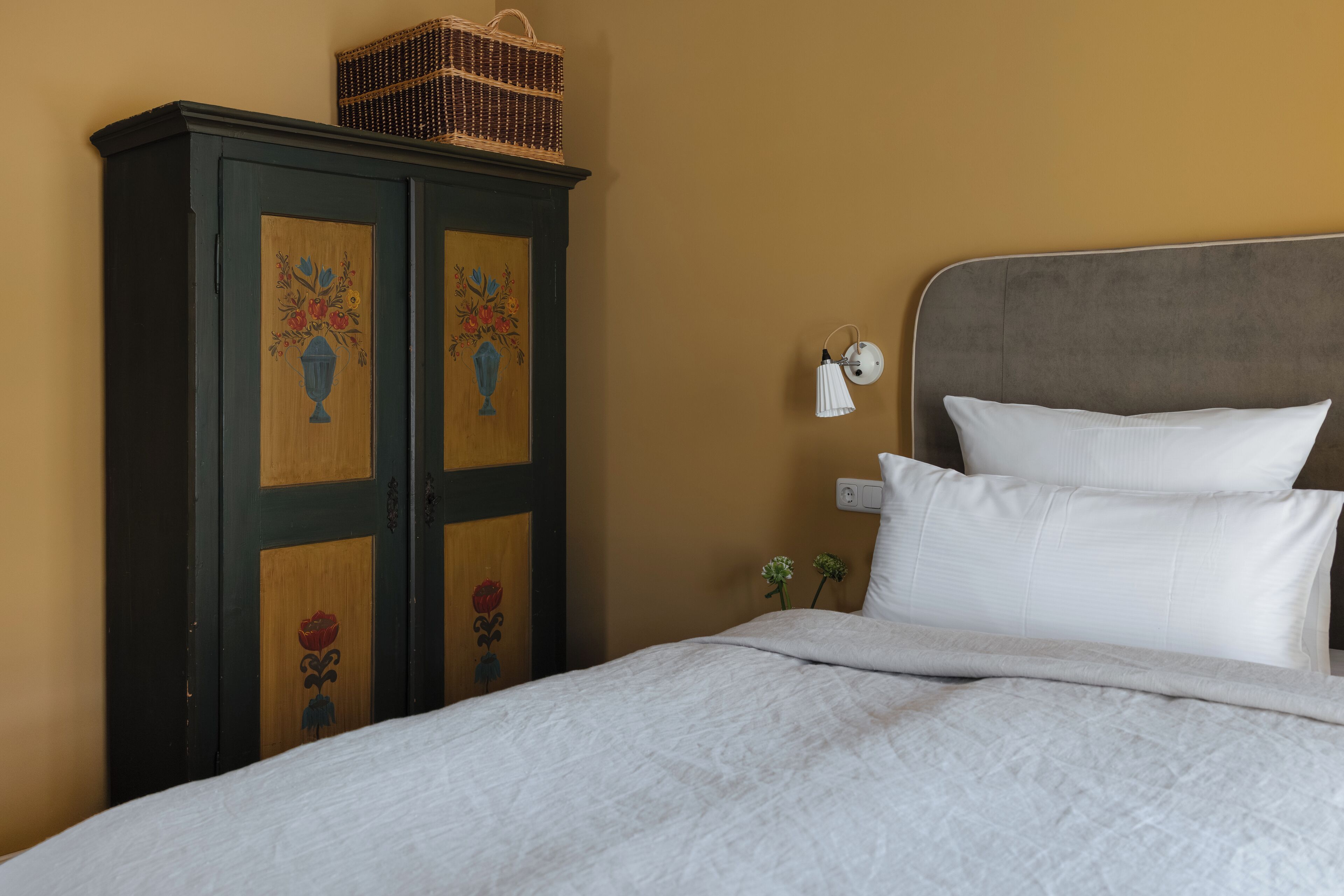 Une chambre à coucher avec un lit, une table de chevet et une armoire.