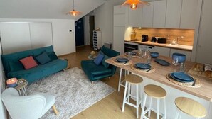 A modern apartment with a living area, a kitchen, and a dining space.
