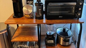 Una encimera de cocina con un tostador, una cafetera, una licuadora, un horno tostador y una olla de cocción lenta.