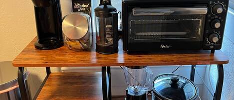 Un plan de travail de cuisine avec un grille-pain, une machine à café, un mixeur, un four grille-pain et une mijoteuse.
