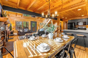 Ein Holzblockhaus-Interieur mit Essbereich, Küche und Wohnzimmer.