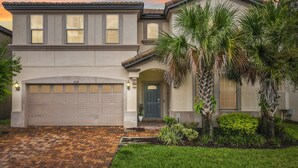 A two-story house with a garage, a front door, and a small garden with palm trees. - Free Pool Heat+BBQ|Fam Resort|Themed Frozen + Harry Potter|Star Wars Gameroom (Kissimmee)