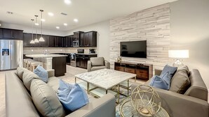 A modern kitchen with dark cabinets, a central island, and a built-in microwave. - Free Pool Heat+BBQ|Fam Resort|Themed Frozen + Harry Potter|Star Wars Gameroom (Kissimmee)