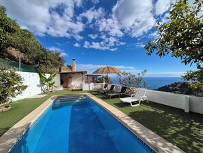 A swimming pool with a view of the sea, a small house with a chimney, and outdoor seating. - Independent house 6 minutes from the beach El Zapo (La Herradura)