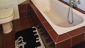 A bathroom with a bathtub, toilet, and a potted plant. - La Casa di Sandhya (Udine)