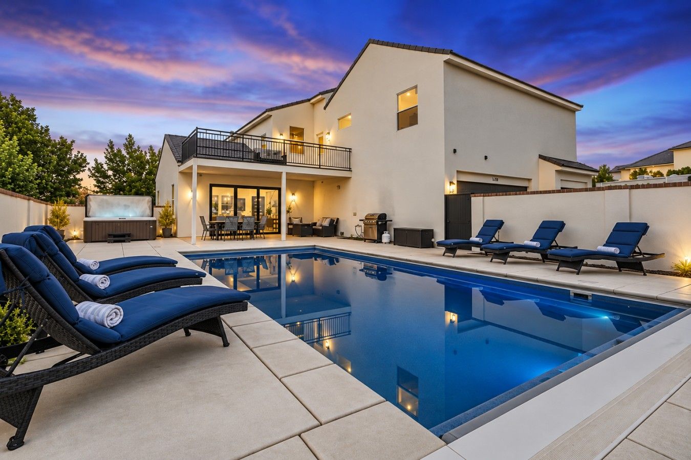 Une maison moderne dotée d’une piscine, d’un espace salon extérieur et d’un patio.