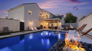 Una casa moderna con piscina e area con fuoco.
