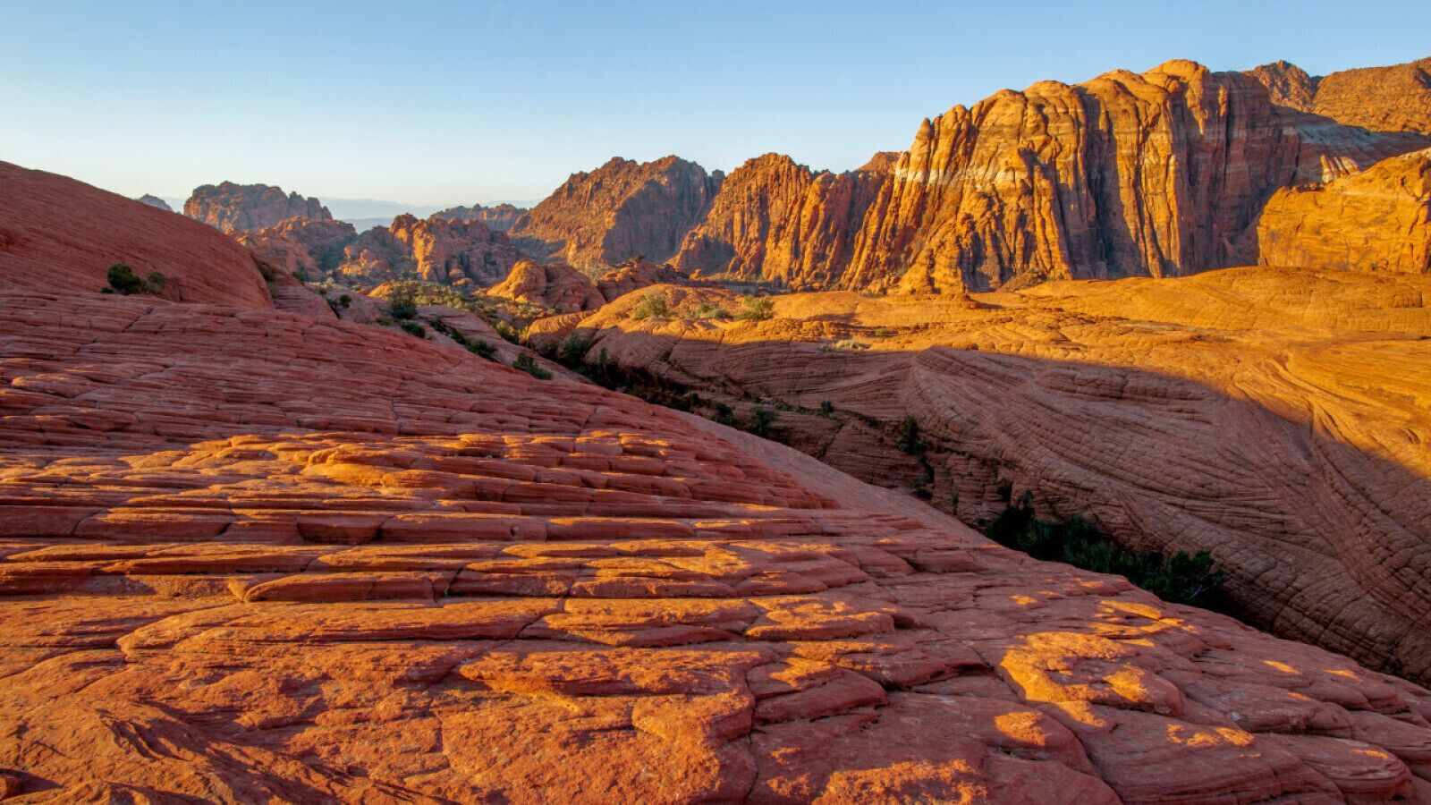 A rugged landscape with layered rock formations and a clear sky.