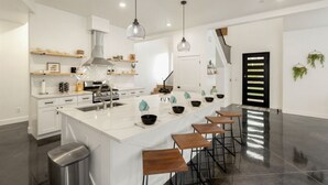 A modern kitchen with a central island, bar stools, and pendant lighting. - Shadow Stone | Private Pool & Spa | 16+ Guests! (Hurricane)