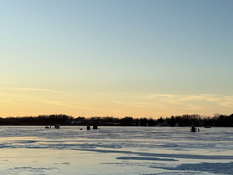 Un lac gelé sur lequel se trouvent plusieurs petites constructions sur la glace.