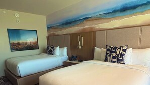 A hotel room with two beds, a painting of a landscape, and a patterned carpet. - Golden Mesa Hotel (Guymon)