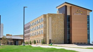 A modern building with a stone facade and a sign reading "GOLDENMESA". - Golden Mesa Hotel (Guymon)