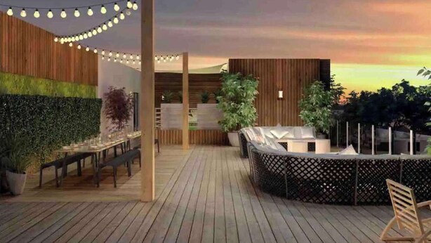 Een houten terras met lichtjes, een eethoek en een zithoek met uitzicht op de zonsondergang.
