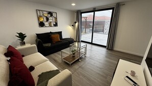 En moderne stue med sofa, sofabord og tv-møbel.